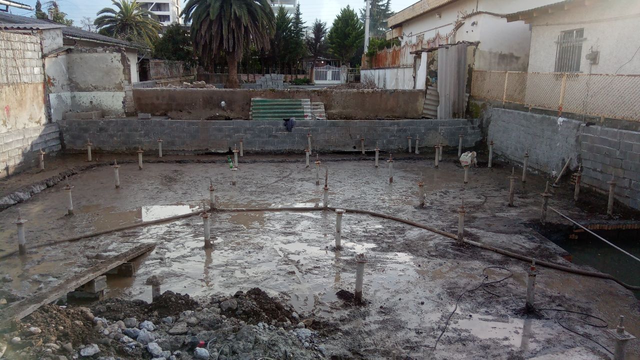 Construction site showing micropile installation for building foundation reinforcement