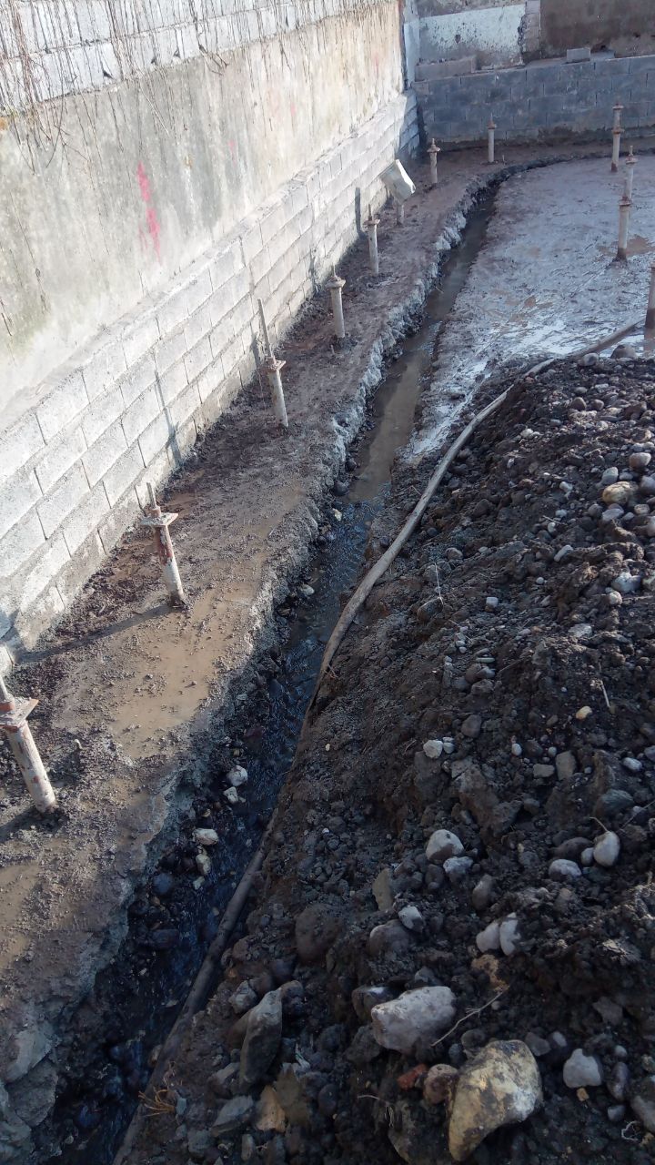 Construction site showing micropile installation for building foundation reinforcement