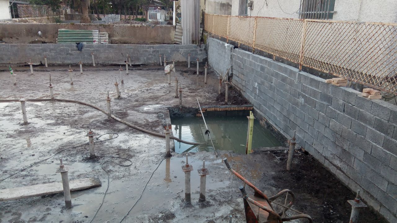 Construction site showing micropile installation for building foundation reinforcement