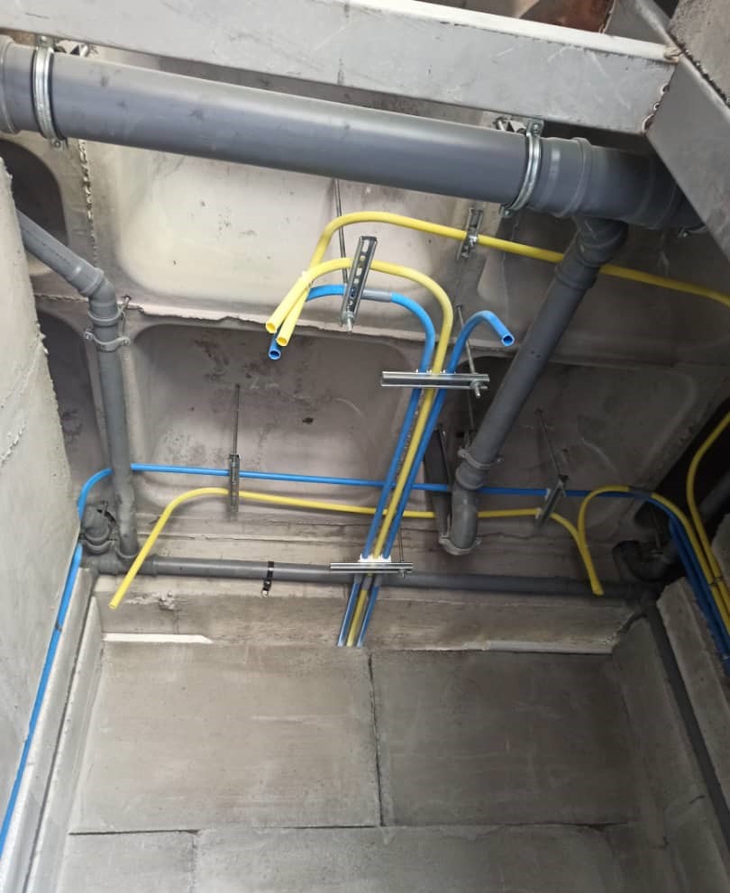 Sanitary piping installation at a building site, showing mechanical plumbing layout