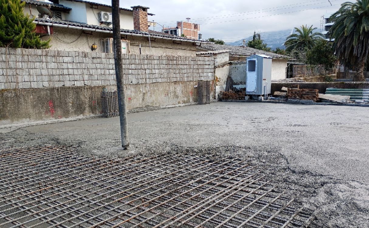 Concrete foundation pouring during structural phase of Redline residential building construction